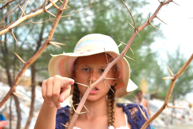 Girl pricked by a thorn. The sharp branches of the Bush. The child is in danger in the forest. Prick your finger with a sharp thorn. Girl pricked by a thorn. The sharp branches of the Bush. The child is in danger in the forest. Prick your finger with a sharp thorn.