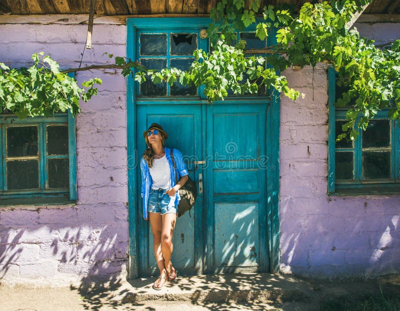 Girl in hat standing near purple wall in Turkish village