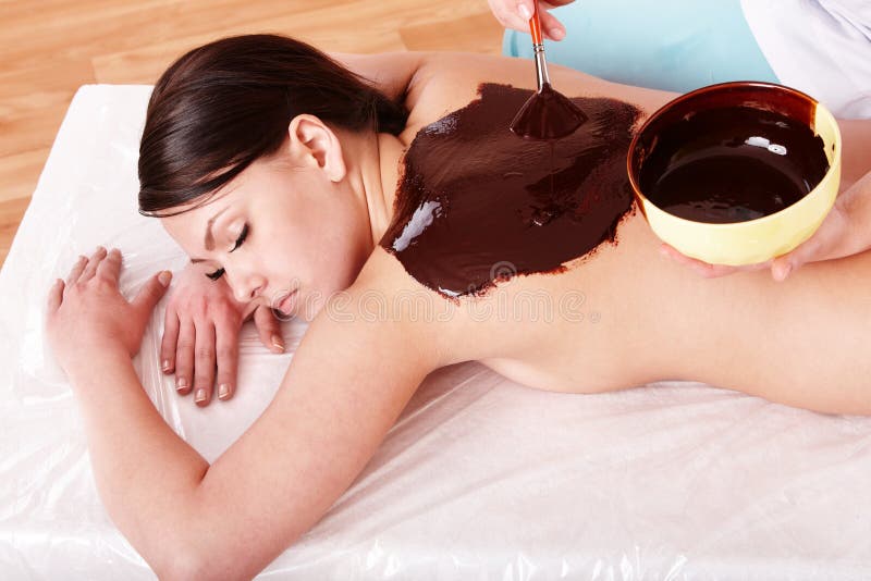 Giovane donna con maschera corpo al cioccolato.