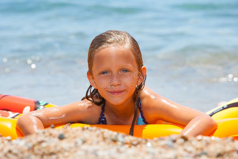 Girl Having Fun on Air Mattress. Stock Photo Image of seashore, child