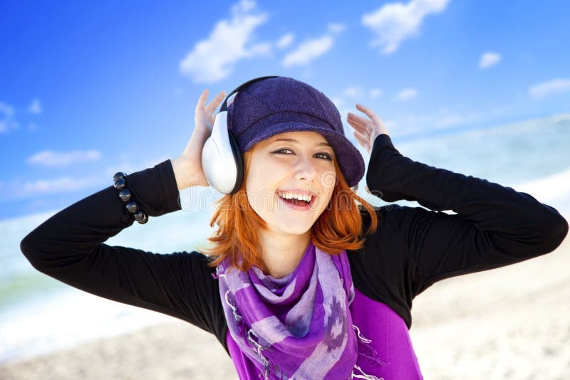 Girl with headphone on the beach.