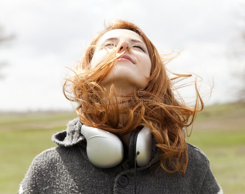 Girl with headphones at spring outdoor.