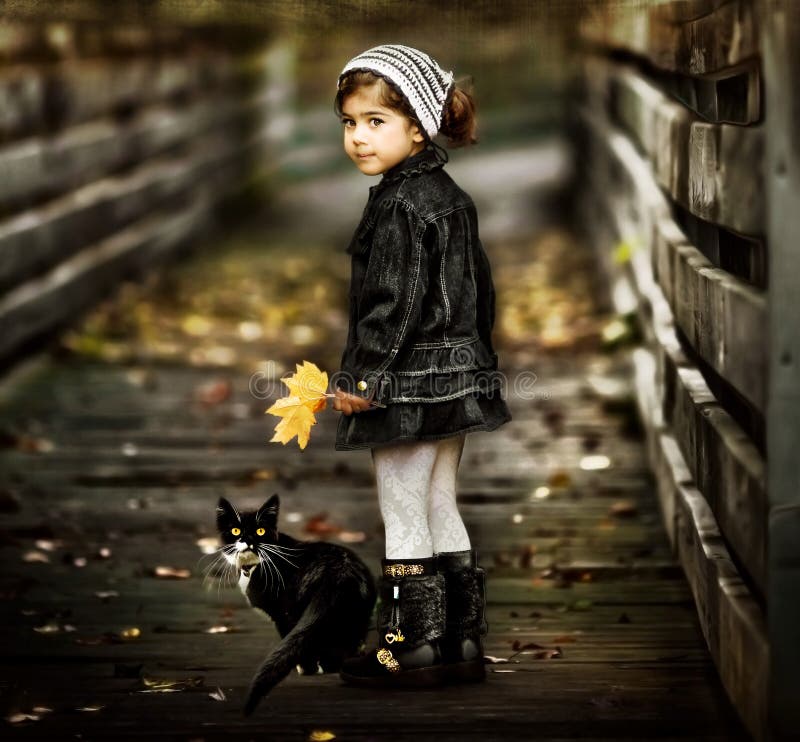 Kleines Mädchen zu Fuß auf die Brücke mit Ihren schwarzen und weißen Katze während der Herbst-Saison in michigan.