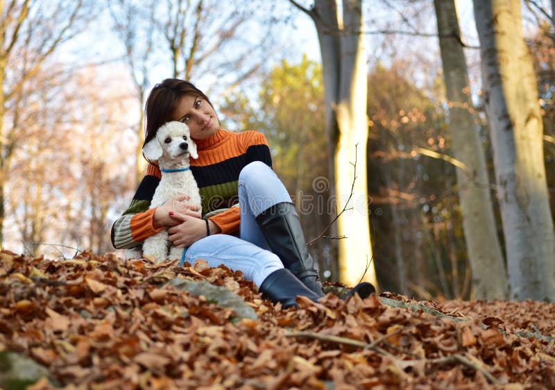 A girl with her dog in colorful autumn