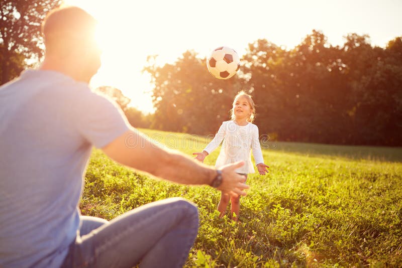 Girl and her father plays with ball