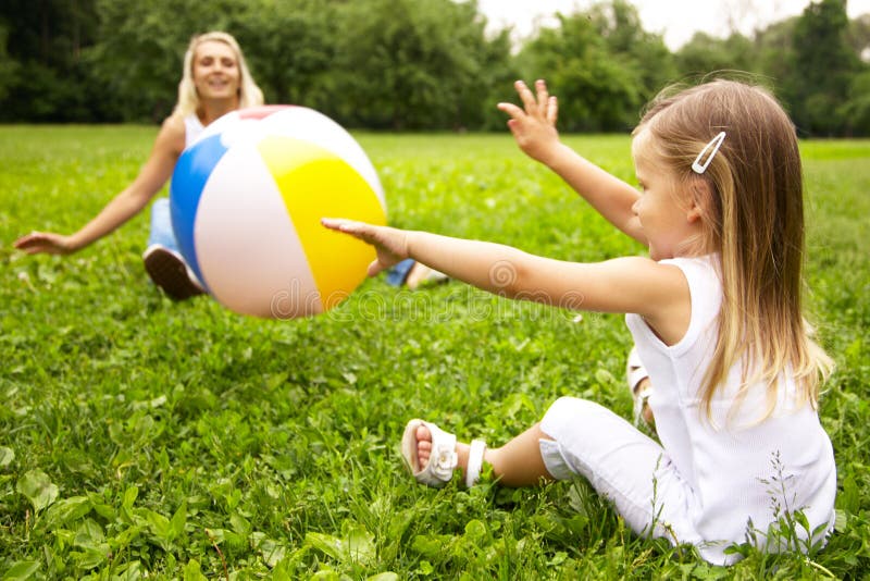 Girl and her mother are playing with ball