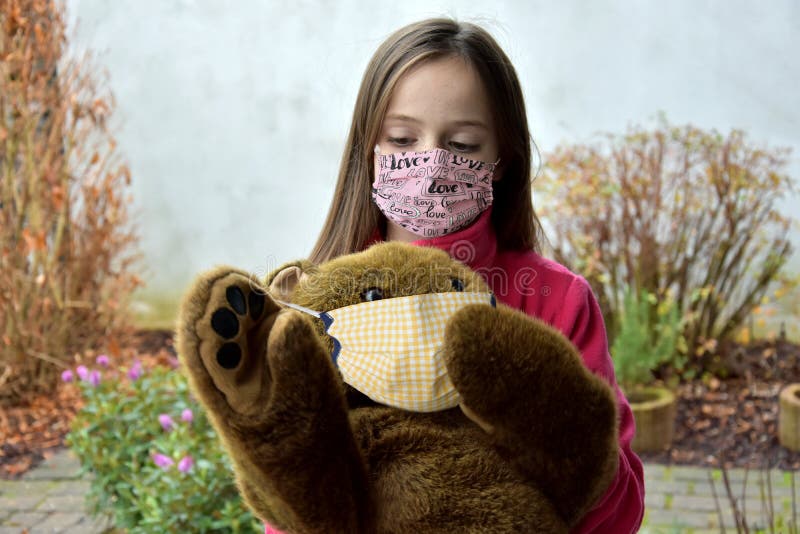Coronavirus, girl and teddy bear in self made protective mask stock photography Coronavirus, girl and teddy bear in self made protective mask stock photography