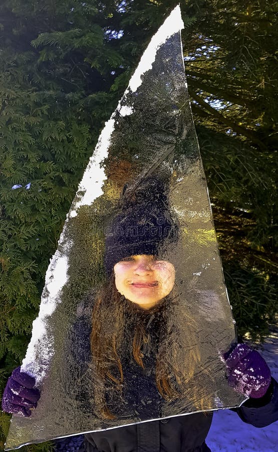 Girl hidden behind piece of ice floe in Choczewo, Pomerania, Poland