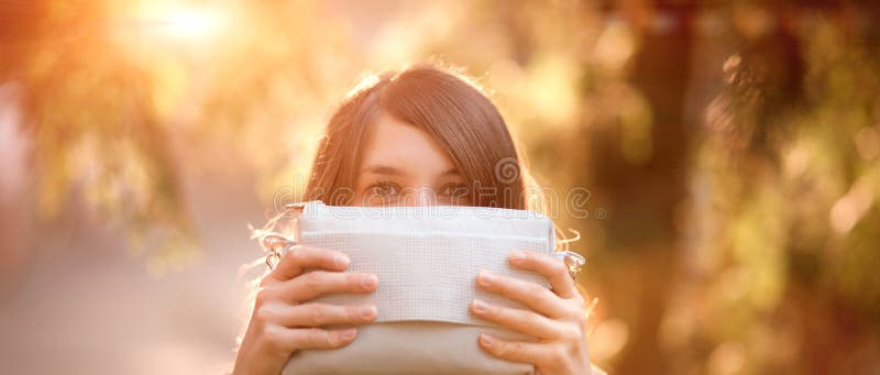 Girl hidding by holding a purse