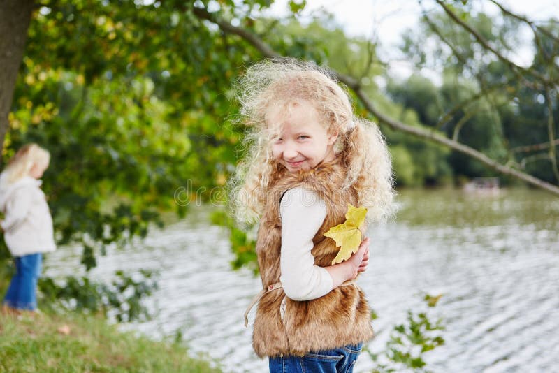 Girl hiding autumn leaf as a surprise stock image Girl hiding autumn leaf as a surprise stock image