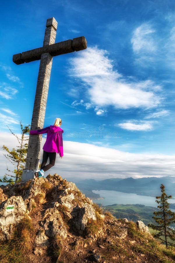 Girl hiker posing with wooden cross on top of the hill Pravnac in Slovakia