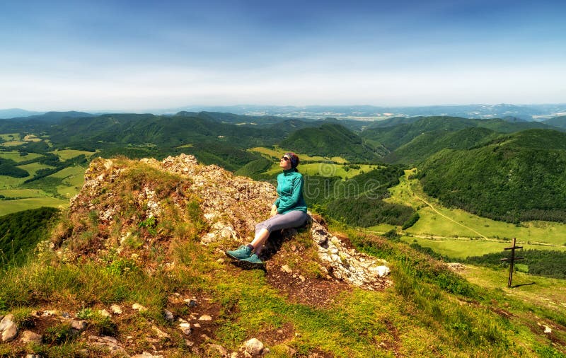 Dívka turistika sedí na vrcholu kopce Strážov s krásnou krajinou. Slovensko