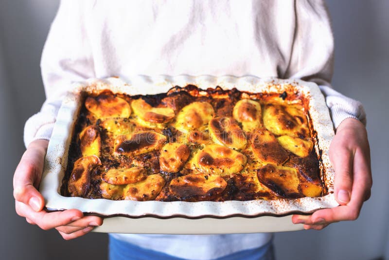 Girl holding baked Greek moussaka in her hands stock photography Girl holding baked Greek moussaka in her hands stock photography