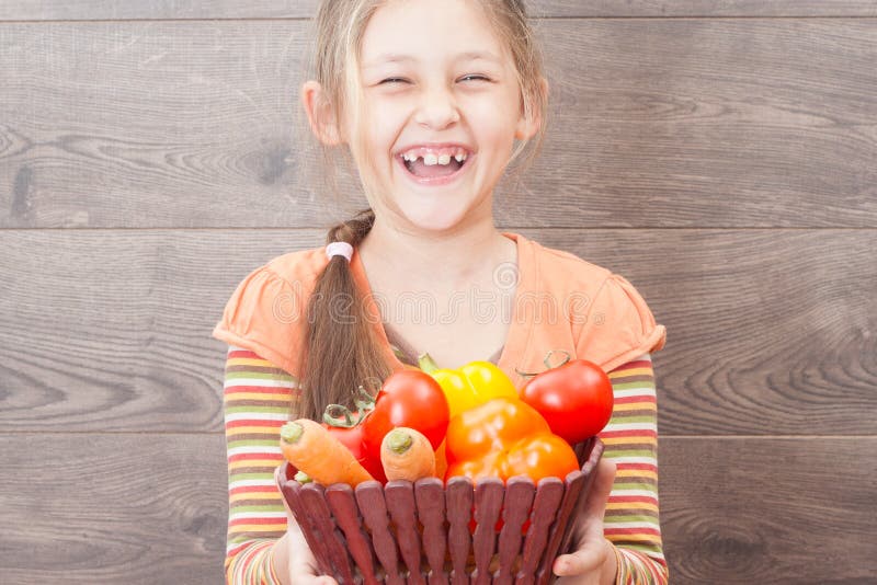 girl holding a basket of juicy vegetables