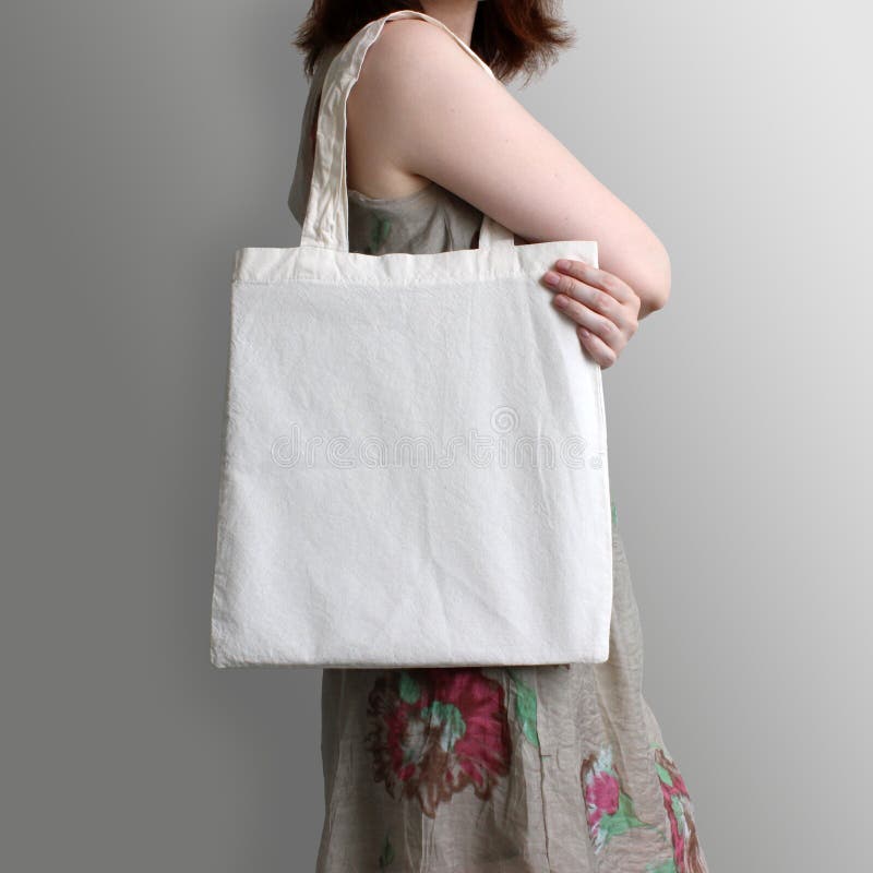 Girl is holding blank cotton eco tote bag, design mockup. Handmade shopping bag for girls.