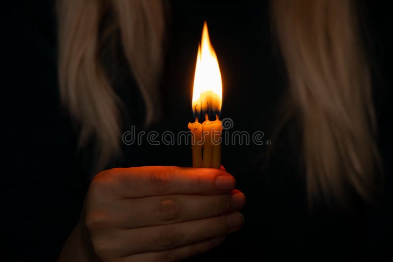 The girl is holding a candle and praying for Ukraine, we all mourn and pray for peace, vryna in Ukraine, hand with a