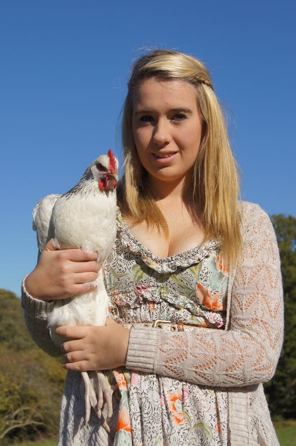 Pretty girl holding a white Sussex-Light chicken.