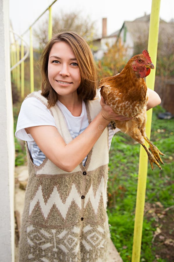 Girl holding a brown chicken.