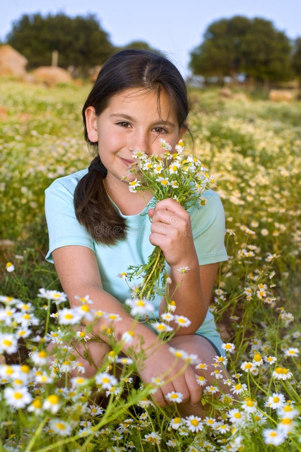 Girl holding flowers in field at sunset