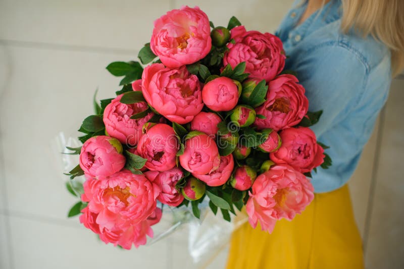 Girl holding fresh pink peony flower