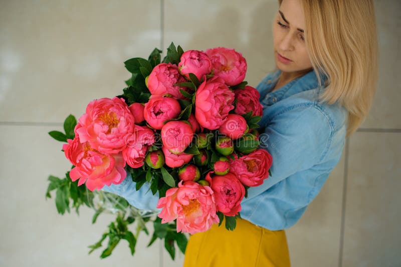 Girl holding fresh pink peony flower