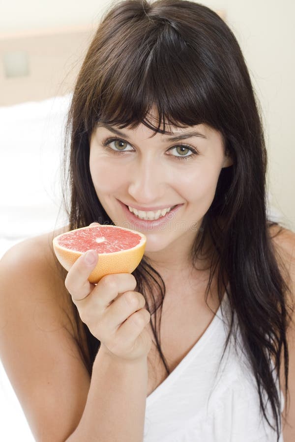 Girl holding of half grapefruit