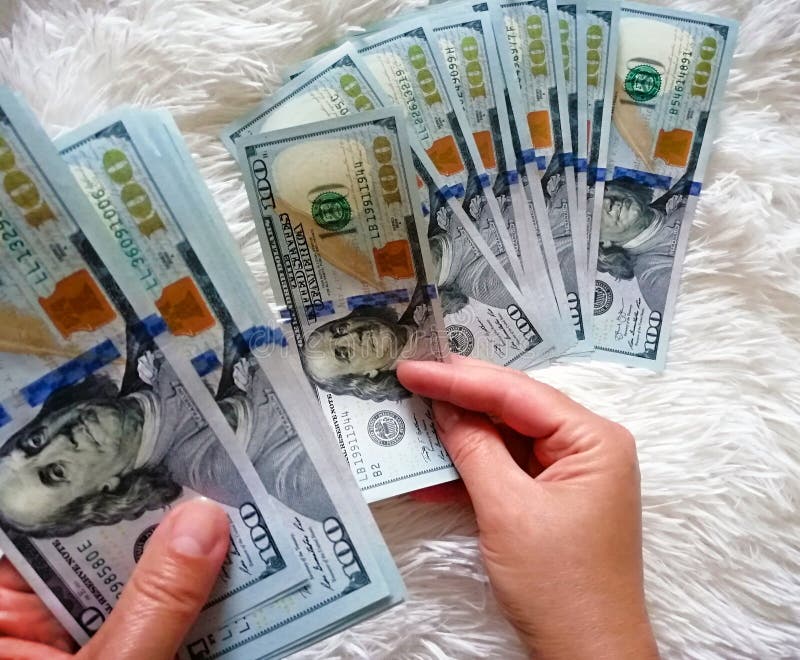 The girl is holding the money in her hands. One hundred dollars cash stock images The girl is holding the money in her hands. One hundred dollars cash stock images