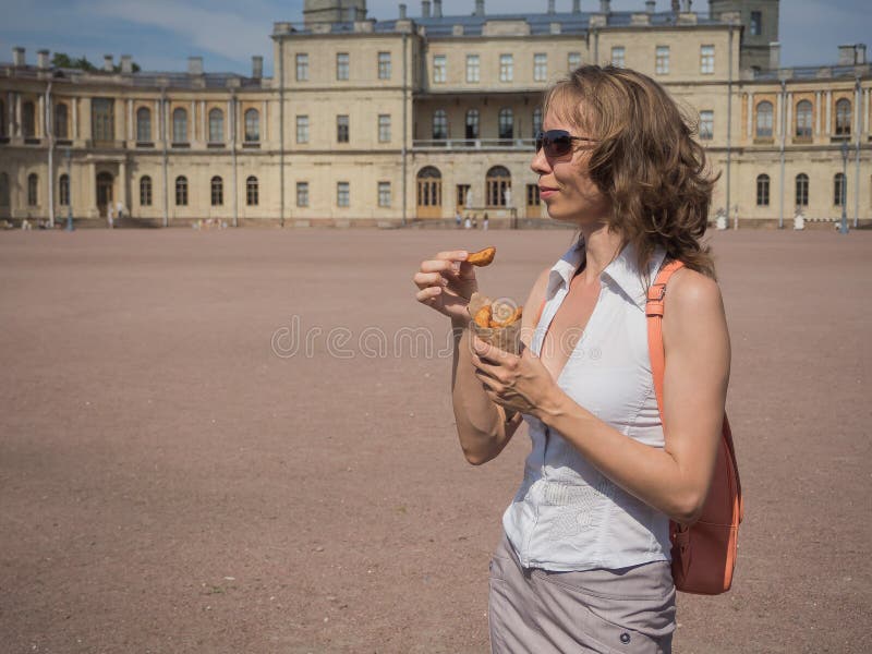 A girl holding a pack of fries in hand in the street. Small pack of potato fries, fast snack stock photography A girl holding a pack of fries in hand in the street. Small pack of potato fries, fast snack stock photography