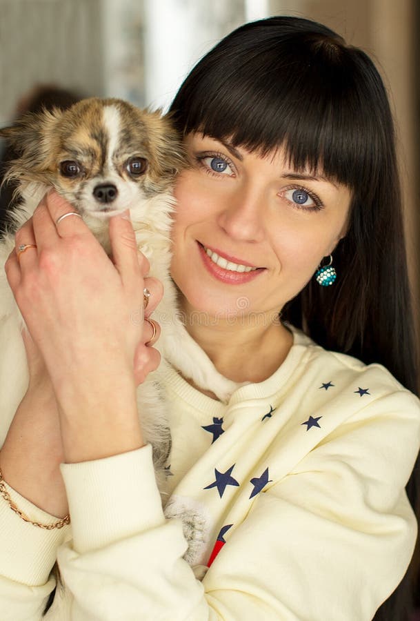 A girl holds a dog in her arms