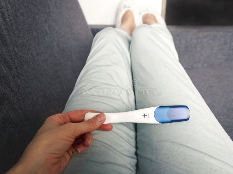 The Girl Holds in Her Hand a Positive Pregnancy Test. the Concept of