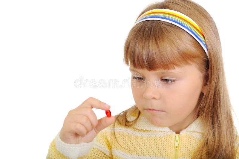 The girl holds a medicinal capsule in a hand