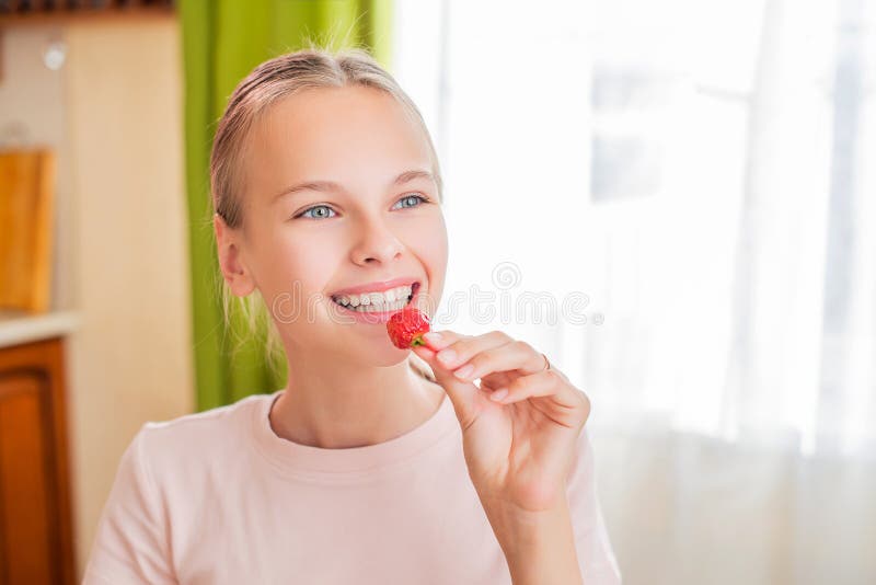 Girl At Home In The Kitchen Sits At A Table Eats Strawberries Cooks Strawberry Jam Stock Image 