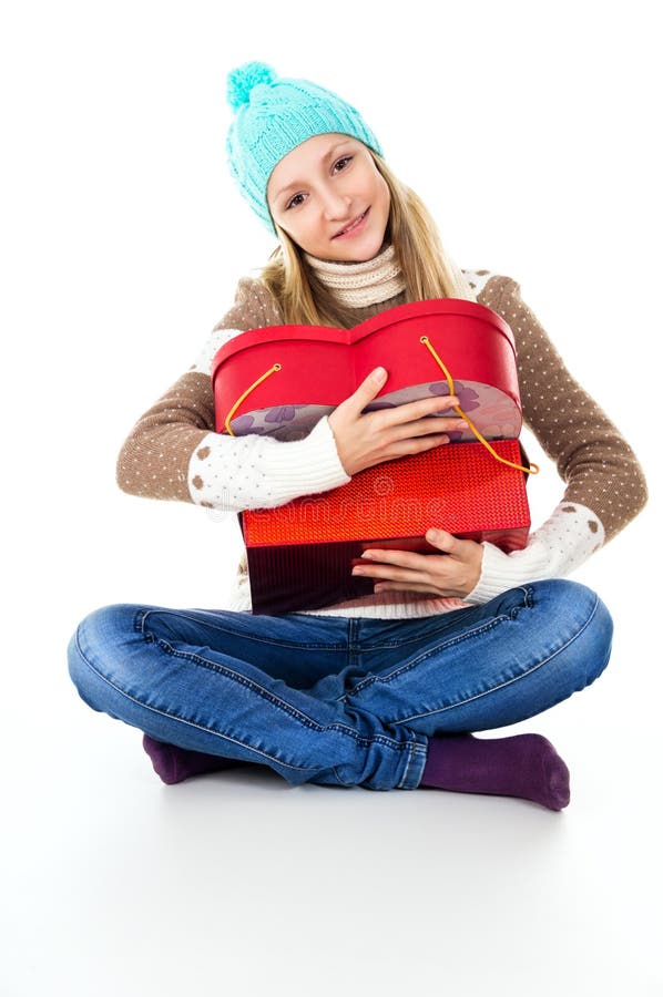 Girl hugs gifts in winter clothes isolated