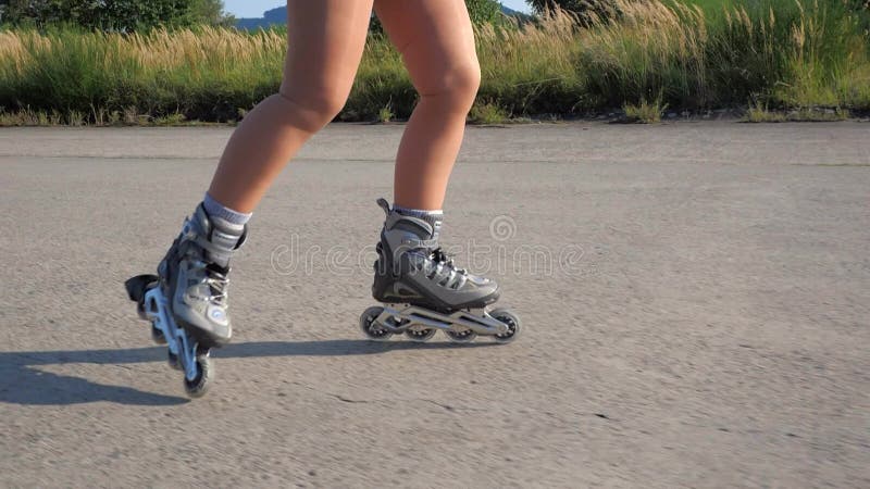 Girl is inline skating wears sports compression stockings and inline skates. Slow motion