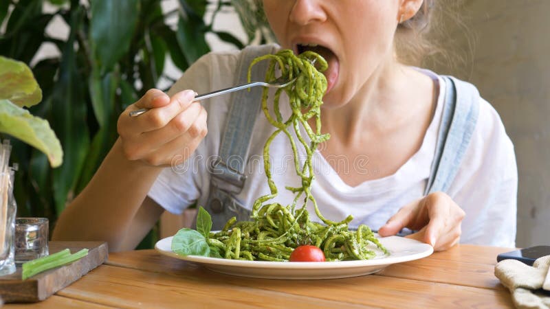 Girl inputs fresh raw vegetable salad on silver fork stock photo Girl inputs fresh raw vegetable salad on silver fork stock photo