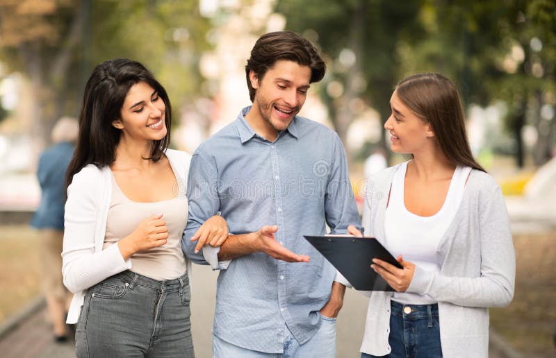 Girl Talking with Married Couple of Friends Walking Outside Stock Photo ...