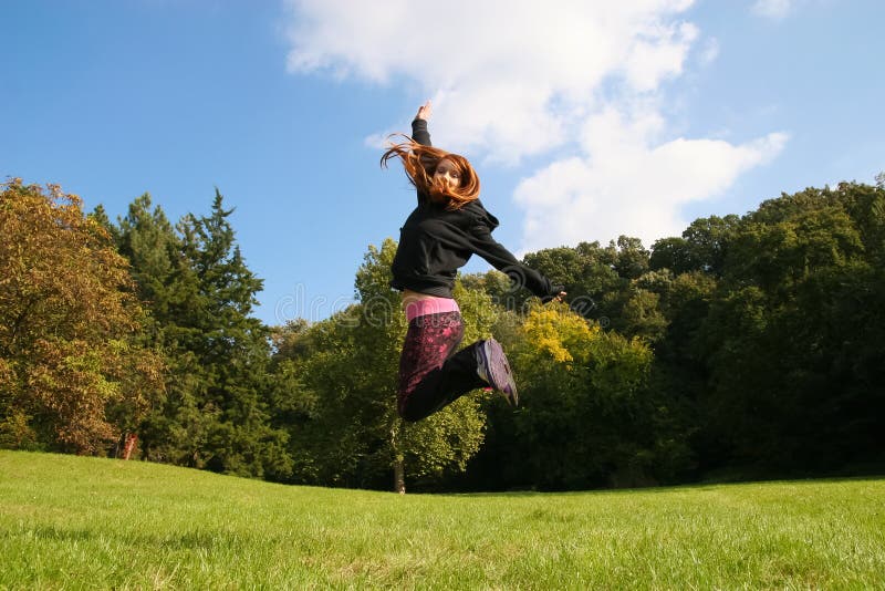 Girl jump on the meadow stock photos
