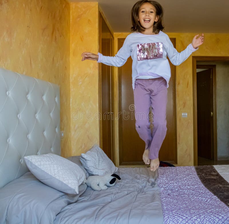 Girl jumping on the bed stock photo. Image of infant 163001004