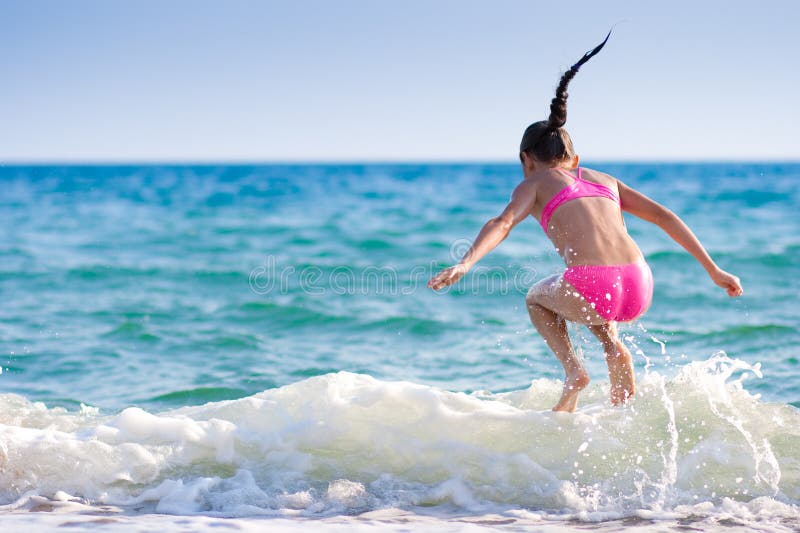 Girl jumping over sea wave. Summer, vacation stock image