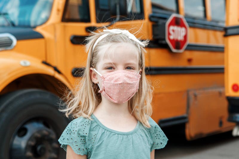 Girl kid student in protective face mask near school yellow bus outdoors. New normal at coronavirus covid-19 pandemic. stock images Girl kid student in protective face mask near school yellow bus outdoors. New normal at coronavirus covid-19 pandemic. stock images