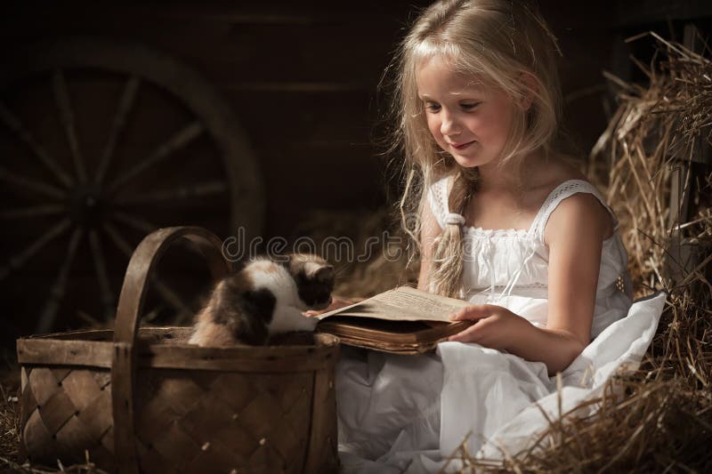 Girl with a kitten on hay