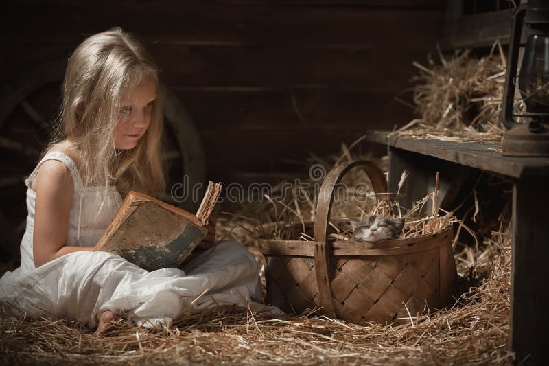 Girl with a kitten on hay