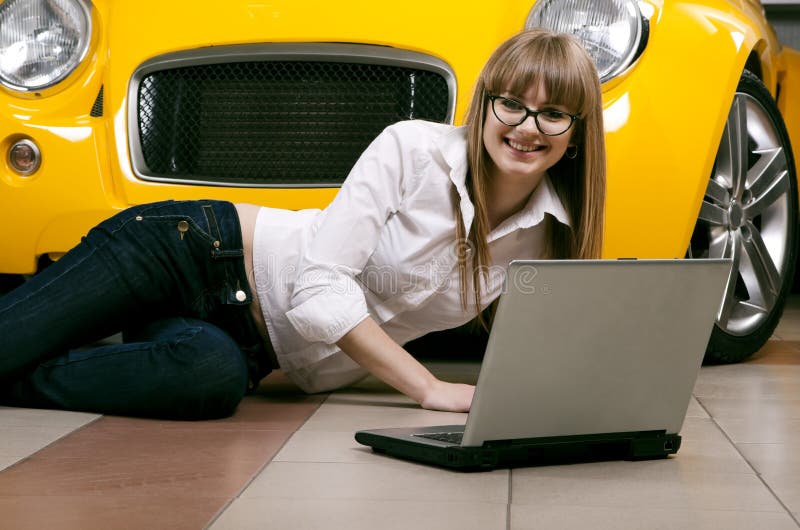 Girl with laptop sitting against of yellow car