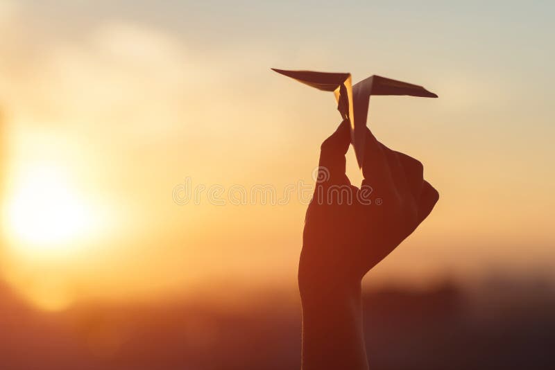 A girl is launching a paper airplane from a window at sunset. Support of the Telegram application and freedom internet.