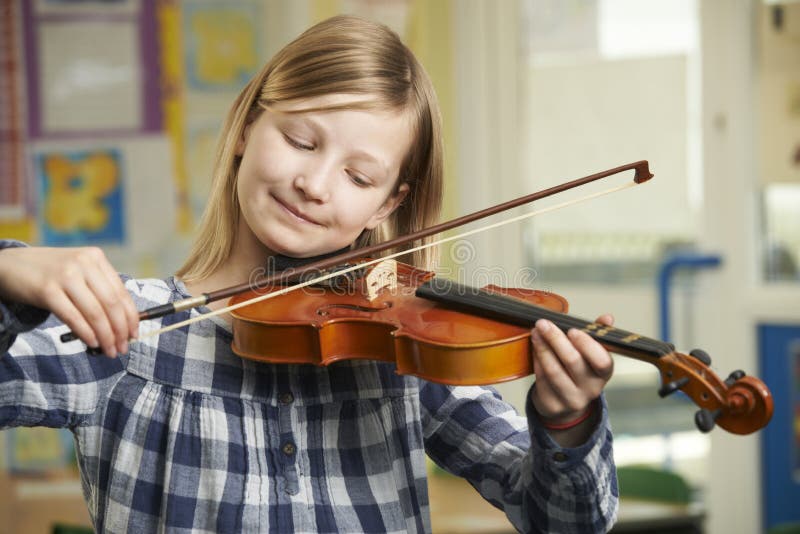 Girl Learning To Play Violin In School Music Lesson