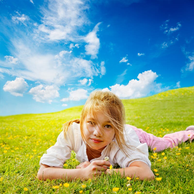 Girl lies in sunny meadow