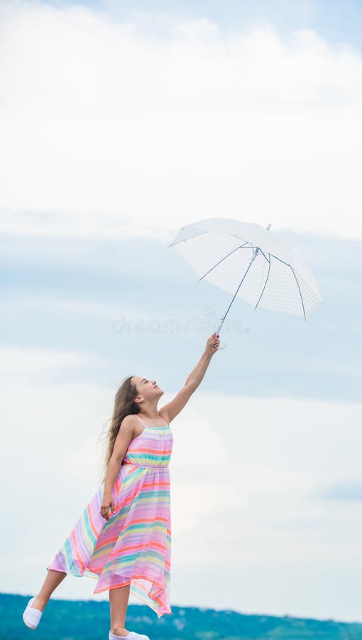 Girl with light umbrella. Anti gravitation. Fly drop parachute. Dreaming about first flight. Kid pretending fly. I. Believe i can fly. Touch sky. Fairy tale stock photos Girl with light umbrella. Anti gravitation. Fly drop parachute. Dreaming about first flight. Kid pretending fly. I. Believe i can fly. Touch sky. Fairy tale stock photos