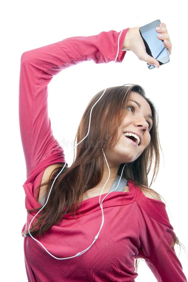Young girl listening, enjoying music and holding cellular mp3 player in earphones on top of her head wearing dance pink top, isolated on white background