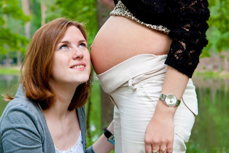 Girl listening pregnant belly