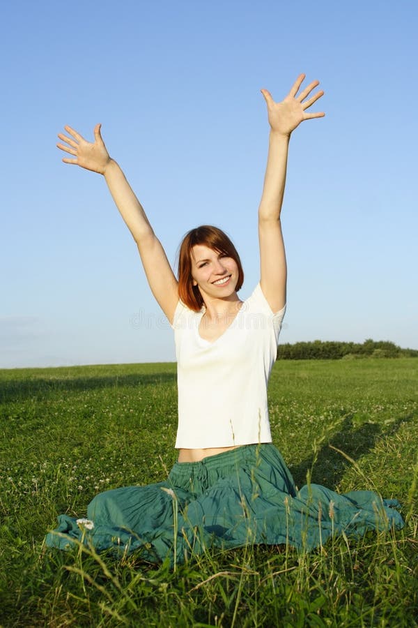 Girl in long skirt sitting on summer lawn